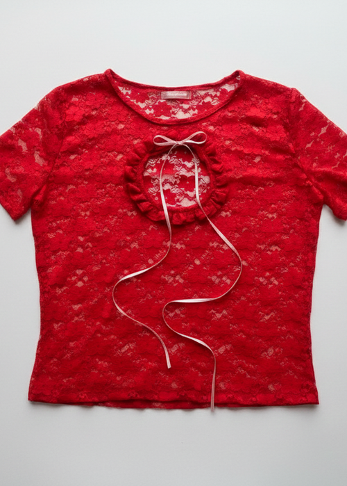 Top confeccionado en encaje suave y delicado, con una textura ligera que se adapta al cuerpo, creando un calce cómodo y favorecedor. Su diseño presenta una abertura frontal circular, enmarcada por un delicado fruncido, que aporta un detalle femenino y sutilmente sensual.

El lazo ajustable en el centro permite regular la abertura y añadir un toque romántico al diseño.